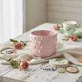 Cachepot in ceramica rosa con decorazioni a rilievo in contesto shabby chic